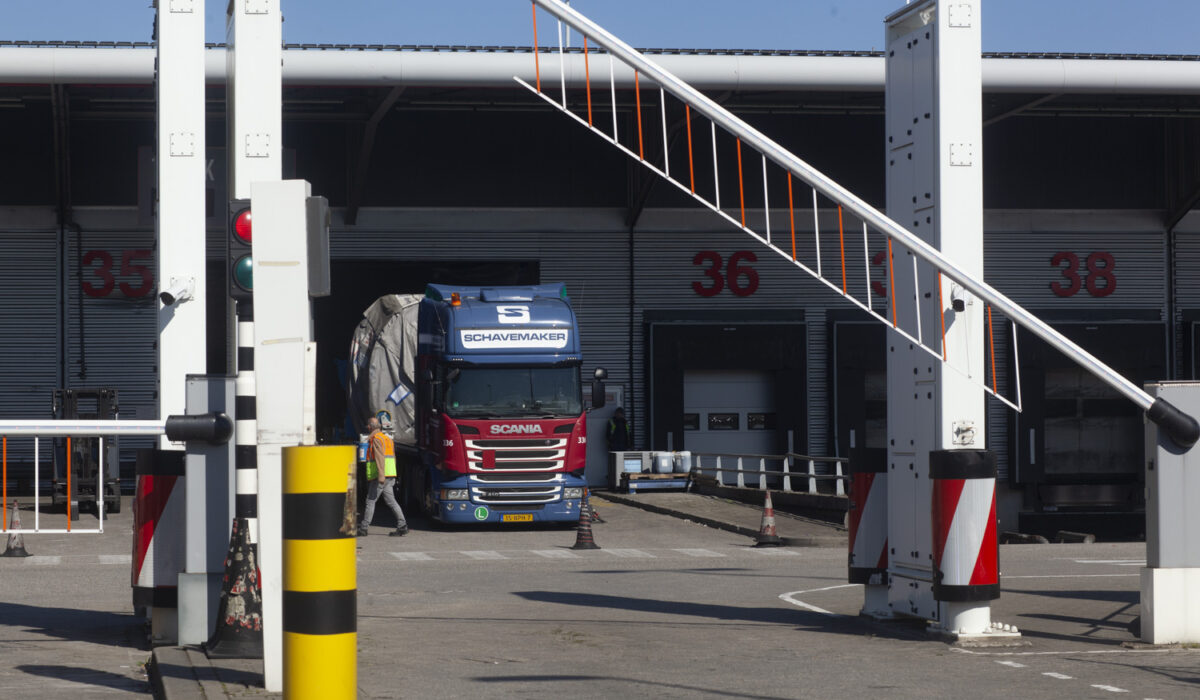Een vrachtwagen wordt gecontroleerd bij een genummerde cargo-dock op Schiphol